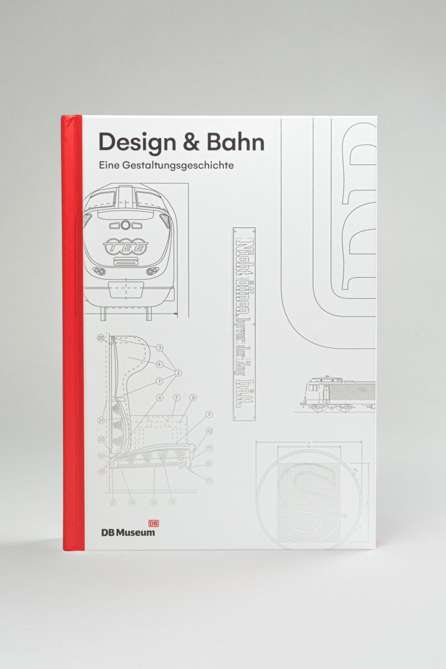 Cover des Buchs „Design & Bahn" als Museumsausgabe mit rotem Buchrücken, hellem Hintergrund und technischen Zeichnungen einer Lokomotive, dem DB Logo und anderen Gestaltungselementen 