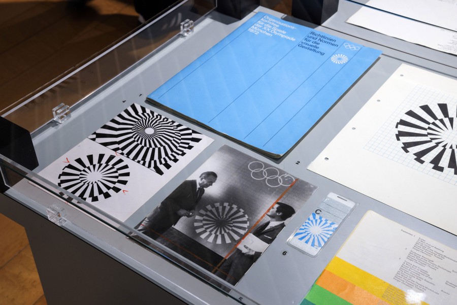Nahaufnahme einer Glasvitrine mit Olympia-Druckerzeugnissen von 1972 und Original-Entwürfen des Olympia-Logos 1972, Original-Foto von Otl Aicher