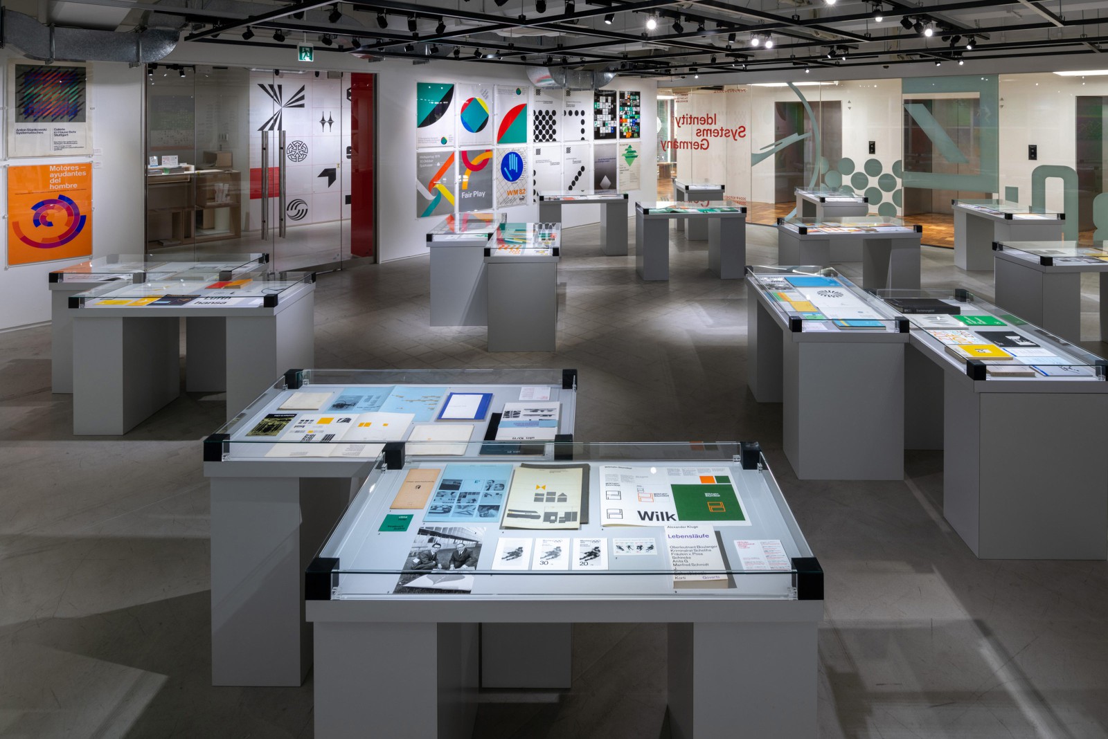 Blick in den Ausstellungsraum der ddd Gallery in Kyoto und Ausstellungsvitrine mit Corporate Design Manuals, darunter Wilkahn Sitzmöbel, Olympia 1972, Stadtwerke Leverkusen, ZDF und mehr