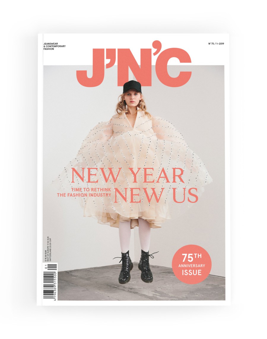 J'N'C Magazin-Cover Nr. 75, Ausgabe 1/2019: Model in weißem Rüschenkleid mit schwarzen Boots springt vor hellgrauem Hintergrund, Titelthema „New Year New Us – Time to Rethink the Fashion Industry", mit ubiläums-Button „75th Anniversary Issue"
