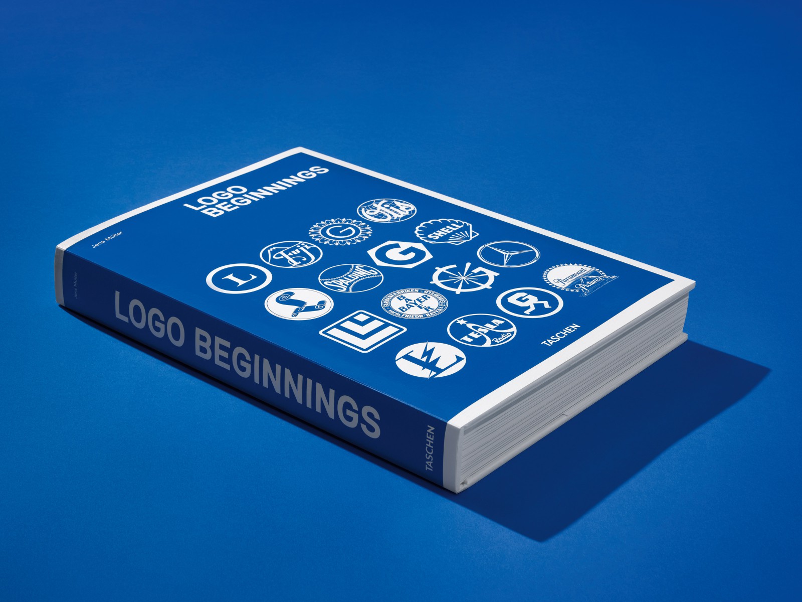 „Logo Beginnings“ Buch Mockup Fotografie mit Vorschau historischer Corporate-Identity-Logos auf blauem Hintergrund