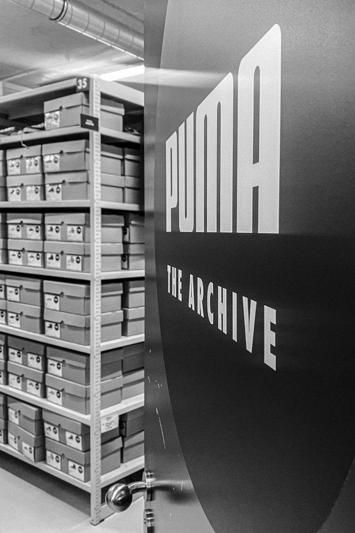 Fotografie des PUMA-Archivlagers mit gestapelten Schuhkartons und „The Archive"-Schild