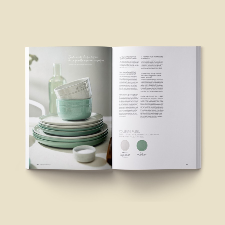 Aufgeschlagene Katalog-Doppelseite mit mintfarbenem Staub-Keramikgeschirr, gestapelten Schalen und Textspalten zur Kollektion auf beigem Hintergrund